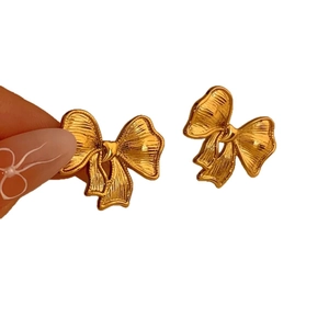 Elegant gold bow earrings with brushed metal texture displayed on a white background