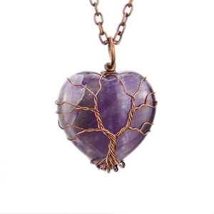 Detailed view of heart-shaped amethyst pendant with copper wire life tree weave