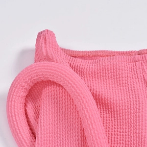 Vue détaillée du tissu seersucker rose avec une texture gaufrée 3D et élastique