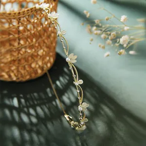 Detail of gold leaf headband with white pearls and crystals on a vintage background