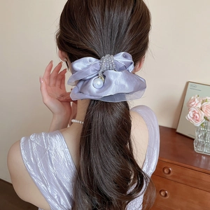Detail of purple organza bow scrunchie with large pearl pendant on hair