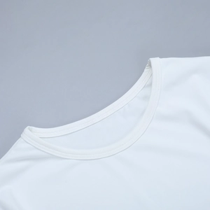 Dettaglio della scollatura rotonda e delle cuciture su un abito in maglia bianco