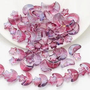 Macro view of purple gradient star and moon glass beads with golden glitter for DIY jewelry