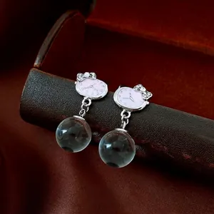 Elegant drop earrings featuring a watch dial design and blue glass beads with crystal bows
