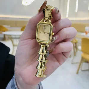 Dettaglio macro del quadrante dorato rettangolare con cinturino vintage a campana