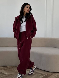 Ensemble sweat à capuche et pantalon large bordeaux dans un décor intérieur minimaliste
