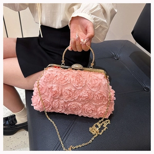 Detailed close-up of pink 3D rose fabric texture on evening bag with rhinestone clasp
