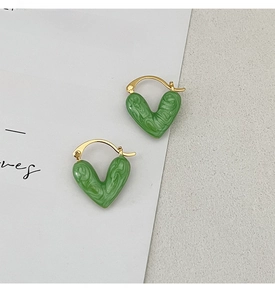 Detail of green heart enamel earrings with marble texture and gold plated hoops