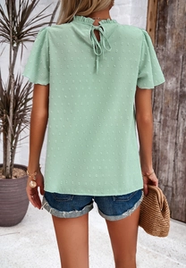 Detail of mint green chiffon top featuring polka dot texture and back tie closure