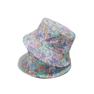 Détail de deux chapeaux de soleil empilés avec imprimés floraux colorés sur tissu léger