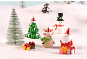 Miniature Christmas resin figurines of Santa, reindeer, and snowman in snowy landscape scenery