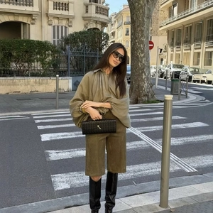 Olive green loose shirt with matching bermuda shorts and tall black leather boots