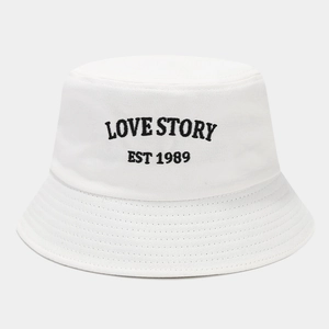 Close-up of LOVE STORY EST 1989 embroidery on a white cotton bucket hat