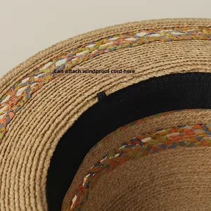Detail view of woven raffia hat interior with sweatband and windproof rope attachment loops