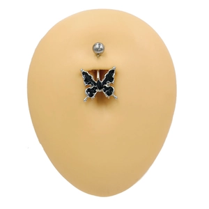 Détail d'un piercing au nombril argenté avec pendentif papillon noir sur modèle