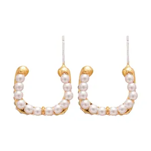 Elegant gold U-shaped C-hoop earrings with pearls and silver pins on white backdrop