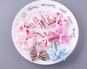 Flat lay of colorful striped and fruit pattern ribbon bow hair clips on a white plate