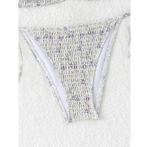 Detailed view of white floral smocked bikini bottom with purple print and side ties