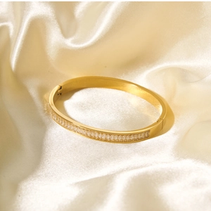 Dettaglio del bracciale in acciaio inossidabile dorato 18k con zirconi su seta pura