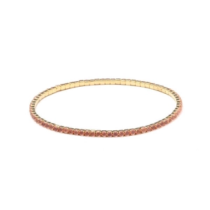 Close-up of pink crystal elastic bracelet with gold-tone setting in a single row