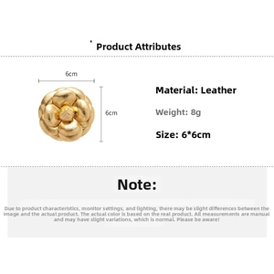 Detailed view of golden leather camellia brooch with size measurements 6cm by 6cm
