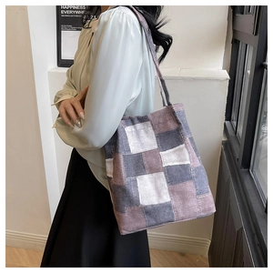 Detail of grey and purple checkered canvas tote bag shown in a casual indoor setting