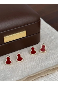 Macro shot of gold-plated red gourd stud earrings with sparkling zircon inlay details