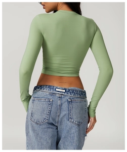 Detail of slim fit light green long sleeve yoga top with cropped cut shown from back view