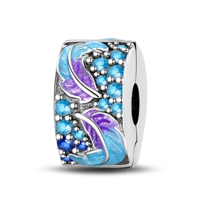 Macro detail of silver feather charm with blue and purple enamel and zircon stones