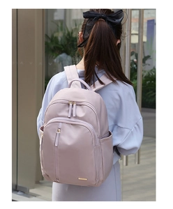 Detalle de una mochila oxford lavanda con estilo en una modelo en una calle moderna