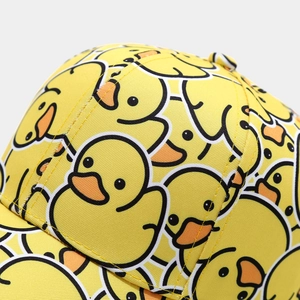 Close-up of bright yellow baseball cap featuring detailed cartoon duck prints and twill fabric
