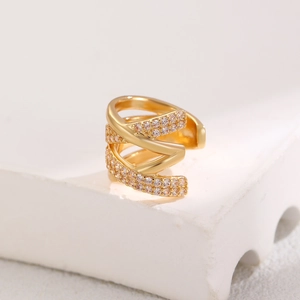 Detailaufnahme der goldenen geometrischen Ohrmanschette mit funkelnden Kristallen im Set
