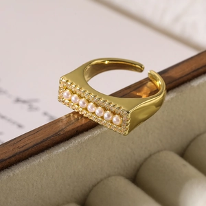 Detail of gold-plated adjustable ring with small pearls and clear cubic zirconia stones