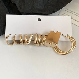 Detail view of stylish gold-finished geometric earrings set on white display card