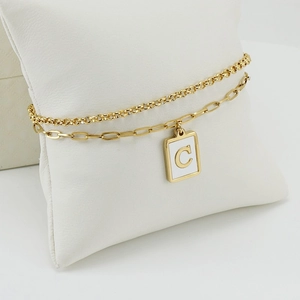 Detailed close-up of a double-layer paperclip chain bracelet with a letter C enamel pendant