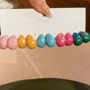 Close-up of ten colorful teardrop earrings with iridescent holographic laser finish