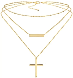 Dettaglio della collana multistrato in acciaio inossidabile dorato con croce