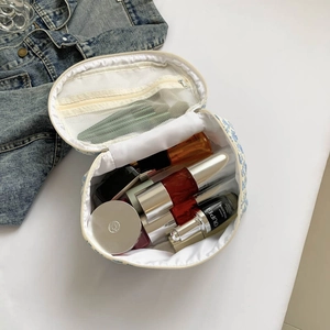 Open view of floral makeup bag showing interior mesh pocket and large main storage space
