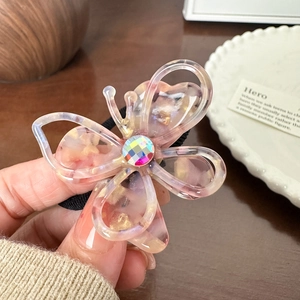 Hollow butterfly acetate hair clip with colorful rhinestones on a black hair tie