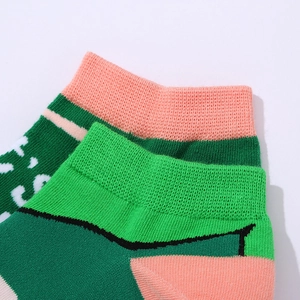Close-up of romantic AB style knit socks with green, pink and white color blocking