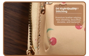 Detailed close-up of metal zipper and cherry pattern on beige leather card holder