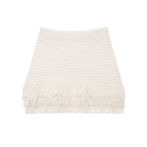 Detail of the ivory knit mini skirt featuring delicate fringe trim on a clean white background