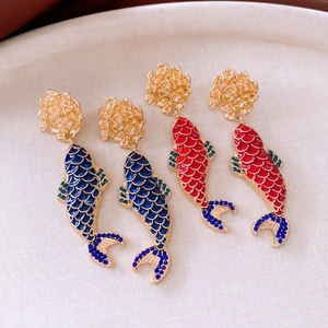 Macro detail of elegant Koi carp drop earrings with colorful enamel and gold finish