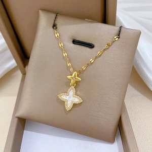 Macro shot of gold clover pendant with sparkling crystals on a premium display box
