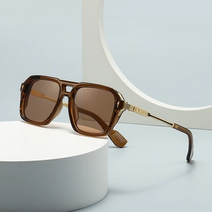 Classic aviator sunglasses with amber frames and gold metal temples on a white pedestal
