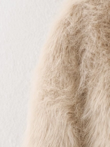 Close-up macro view showing soft fluffy faux fur texture of the beige plush jacket