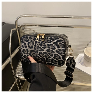 Dettaglio della borsa a tracolla leopardata grigia con zip dorata e ampia tracolla nera
