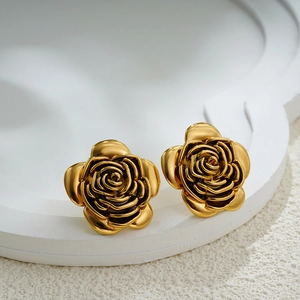 Macro view of 18K gold rose stud earrings featuring detailed layered flower petals