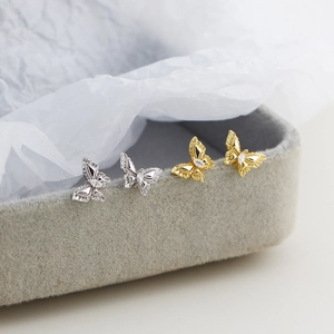 Vue macro de boucles d'oreilles papillon avec cristal en finitions argent et or