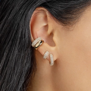 Detail of 18K gold hoop earrings set with pavé cubic zirconia on model ear